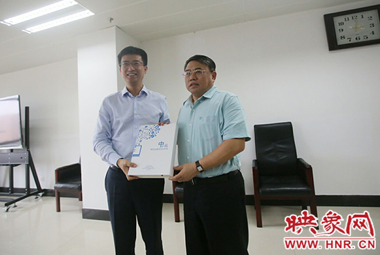 阿里云計(jì)算總裁胡曉明向河南省新聞出版廣電局局長朱夏炎遞交《中原云平臺(tái)交付手冊》。