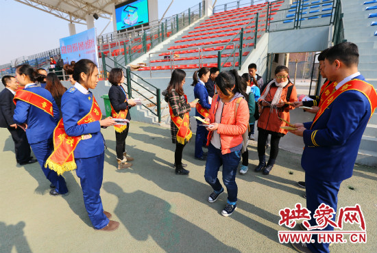 活動(dòng)現(xiàn)場(chǎng)工作人員給同學(xué)們發(fā)放宣傳冊(cè)、環(huán)保袋。