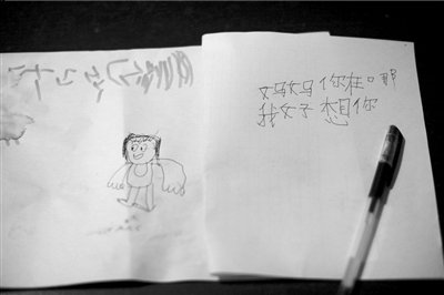 名叫袁明燕的小姑娘用筆在紙上不斷寫“媽媽”二字。