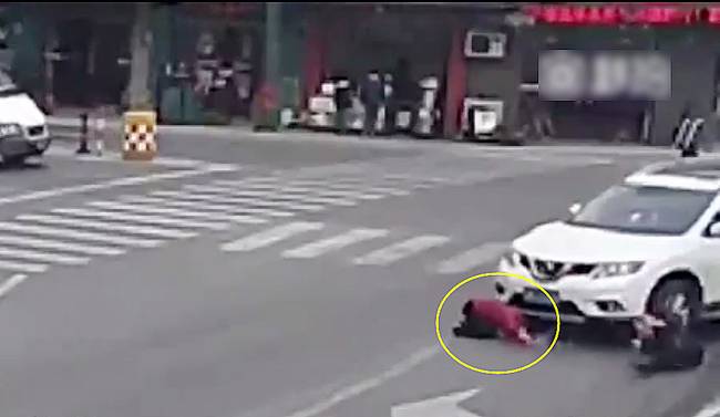 圖為小姑娘被卷進(jìn)車輪下瞬間。