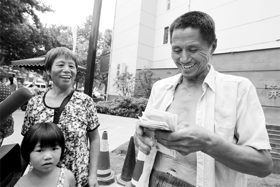 昨日，鄭州市明達路與豐慶路交叉口西300米路南，來自中牟的瓜農(nóng)拿到西瓜款，笑開顏東方今報記者袁曉強