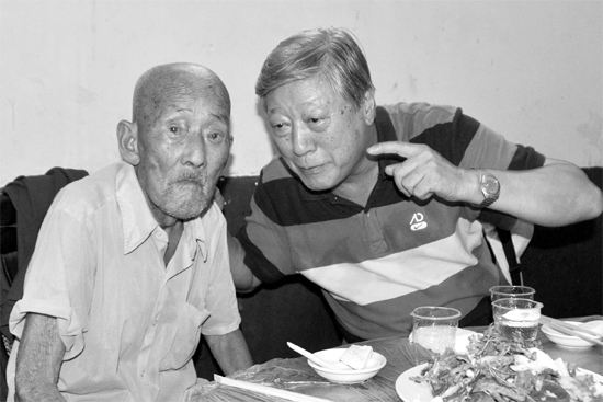 昨日，來(lái)自北京的英雄后代胡冠軍（右）專(zhuān)門(mén)趕到西平縣看望抗戰(zhàn)老兵孫殿修老人