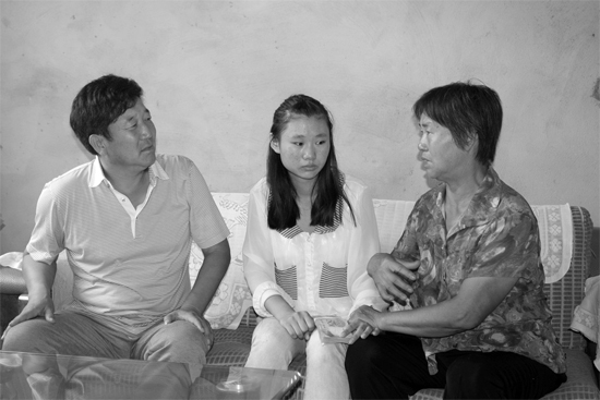 “商丘最美女兒”李丹（中）捐骨髓救母，愛心人士（左）送來(lái)1萬(wàn)元愛心款