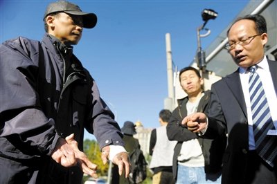 常林鋒在法院外展示雙手，他稱被燙傷的手因刑訊逼供且未得到及時救治