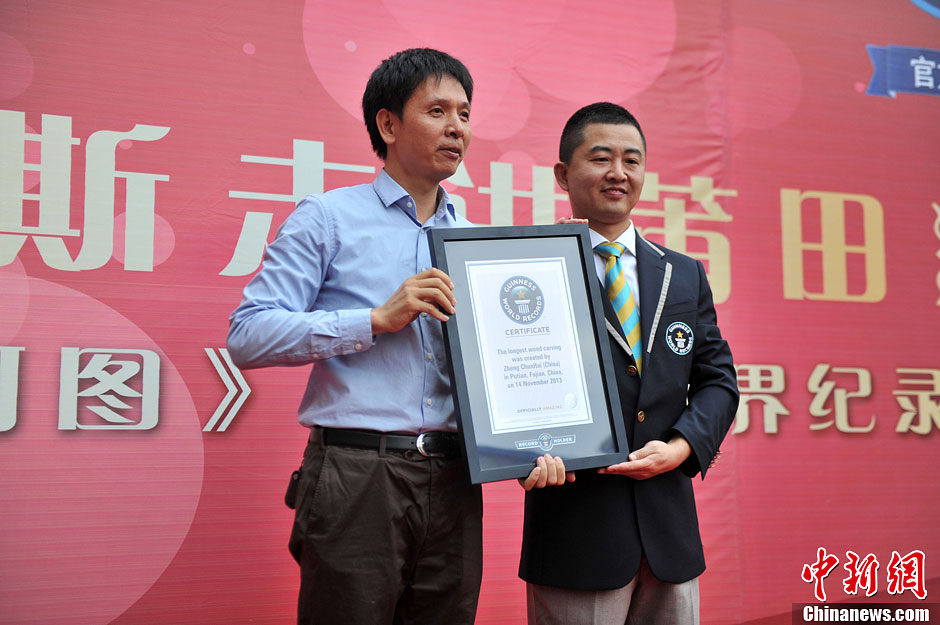 圖為世界吉尼斯認(rèn)證官為鄭春輝（左）頒發(fā)證書(shū)。呂明 攝