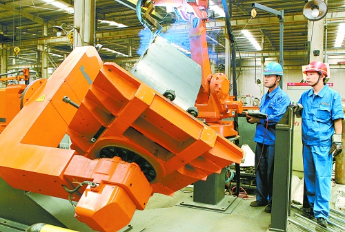 圖為龍工集團(tuán)中原公司的職工正在操作機(jī)器人焊接裝載機(jī)。