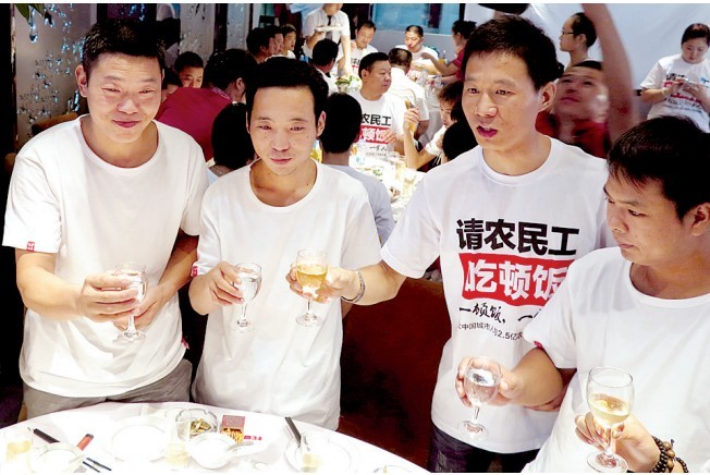 活動(dòng)發(fā)起人張楠（右二）給農(nóng)民工敬酒。
