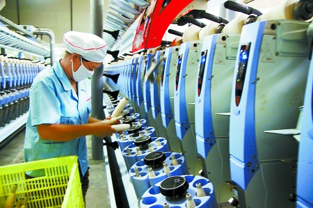 7月3日，在鄧州市永泰棉紡有限公司電腦控制全自動紡紗車間，紡織工人正在生產(chǎn)棉紗。