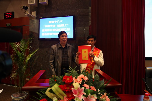 河南平頂山魯山縣電視臺的記者張朝岑，接過了河南電視臺9頻道總監(jiān)張克宣遞上的聘書。