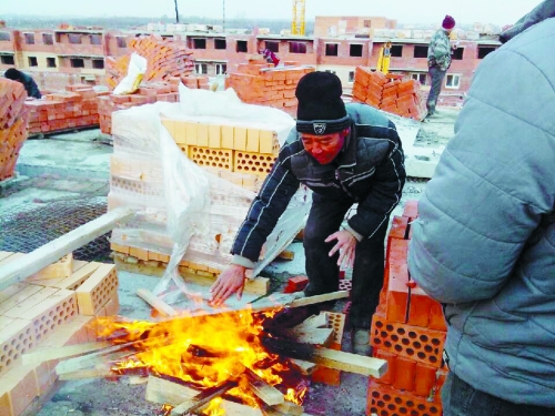 在俄羅斯工地打工時(shí)，因?yàn)樘焯?，工人不得不在工地生火取暖。（圖由方先生提供）