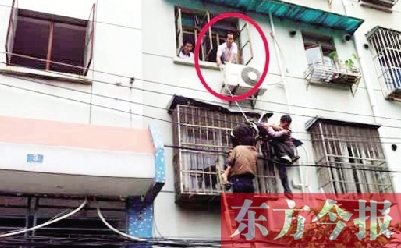 施救現(xiàn)場(chǎng)，劉鵬（圈內(nèi)）先用繩子捆住老太確保安全 勞動(dòng)報(bào)記者 郭娜 供圖