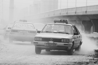施工的道路上，車輛通過塵土飛揚(yáng)。