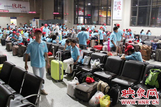 大學生志愿者在火車站候車室內(nèi)整裝待發(fā)。