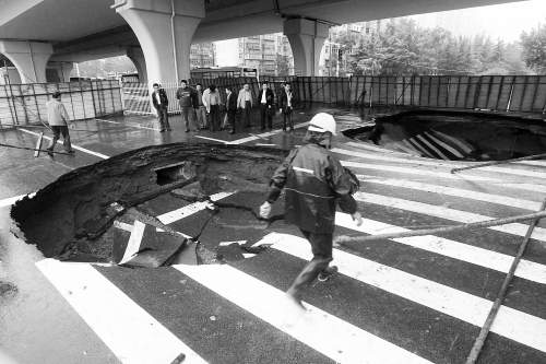 中原路西三環(huán)立交橋下由南向北原本4個車道，由于塌坑，而今3個車道被圍擋