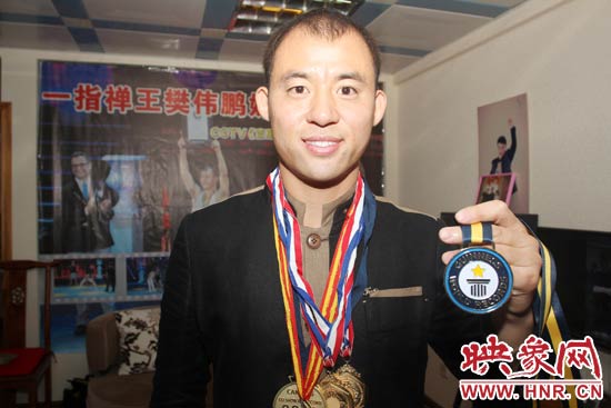 樊偉鵬向大家展示自己剛獲得的吉尼斯獎(jiǎng)牌。