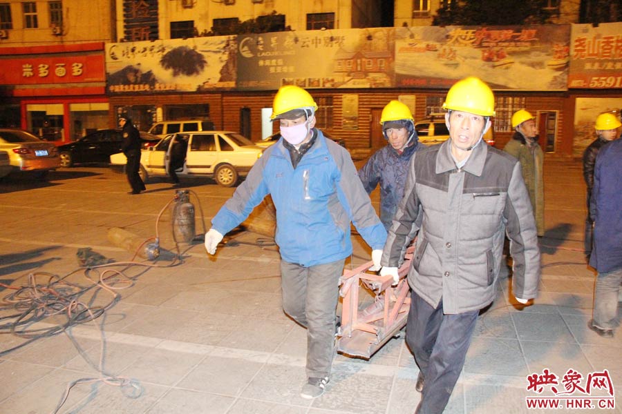 23點(diǎn)56分，第一塊兒廣告牌已經(jīng)分割完畢，地面上的20多名工人將拆除下來的鋼件撞車運(yùn)走。