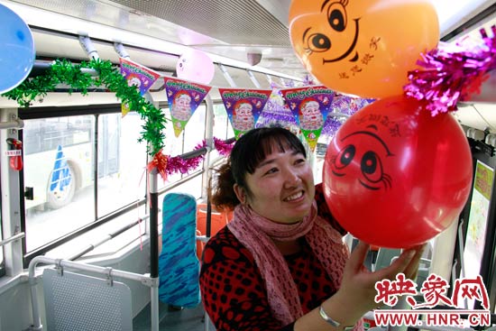 鄭州快速公交B3區(qū)間線(xiàn)車(chē)長(zhǎng)李鵬云在車(chē)廂里懸掛氣球，布置圣誕車(chē)廂，營(yíng)造歡樂(lè)圣誕氛圍