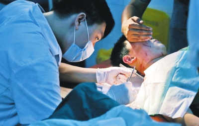 孩子身上有7道傷痕，其中兩道需要縫合，其他的均為擦傷，醫(yī)生正對(duì)他施治。