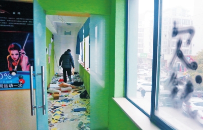 　健身會所地上一片狼藉，玻璃上噴著黑色“欠錢”二字。