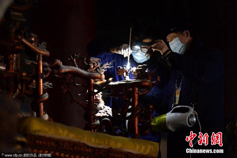 圖為工作人員使用軟毛刷和吸塵器對(duì)太和殿的金漆雕龍寶座除塵。