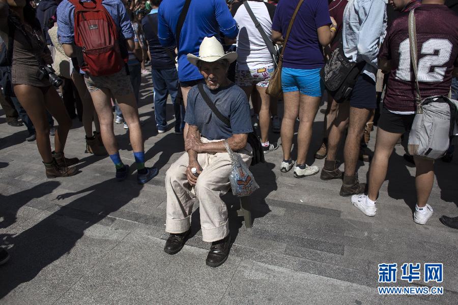 一名男子坐在參加不穿褲子搭地鐵的人群邊小憩。