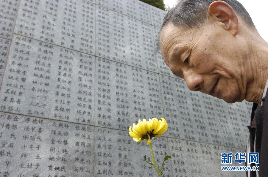 2006年4月5日，74歲的南京大屠殺幸存者佘子清手捧鮮花，祭奠被日軍殺害的母親。