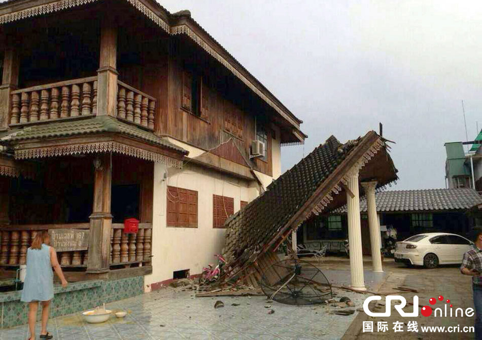 當(dāng)?shù)貢r(shí)間2014年5月5日，泰國(guó)清萊，一名婦女看著受損的房屋。 圖片來(lái)源：東方IC