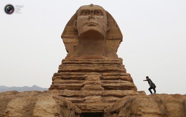 石家莊郊外，一名男子與山寨版獅身人面像合影留念。