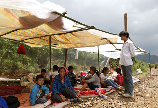 暴雨馬上來(lái)臨，村民們?cè)诤?jiǎn)易帳篷下躲雨。澎湃新聞 程藝輝 圖