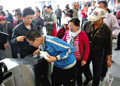 去年5月5日，14號(hào)線園博園站，乘客刷卡出地鐵。北京公交地鐵將實(shí)行計(jì)程票制，多乘坐多付費(fèi)。