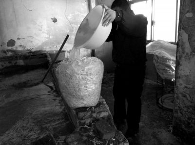 作坊內(nèi)工人用攪拌有漂白粉的藥水給豆芽增白。