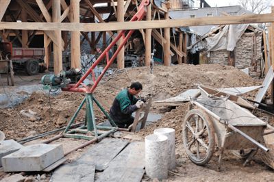 東城區(qū)北鑼鼓巷與小經(jīng)廠胡同之間一處四合院內(nèi)，工人進(jìn)入已經(jīng)挖好的地下室內(nèi)施工。