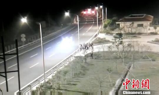 看到車輛經(jīng)過，孩子們便急忙跑到一旁的花圃上?！【焦﹫D　攝