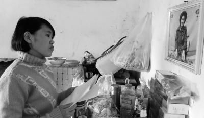 錢仁鳳站在母親遺像前。未能見母親最后一面是她的一大遺憾。