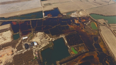 4月19日，廊坊市大城縣南趙扶鎮(zhèn)，津保路以北約八九百米處，一個(gè)巨大的污水坑中，水體呈現(xiàn)紅褐色。 新京報(bào)記者 尹亞飛 攝