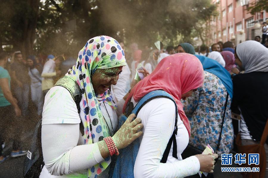 10月16日，在埃及首都開羅，兩名女青年在“彩色跑”活動中躲避人們拋撒的彩色粉末。
