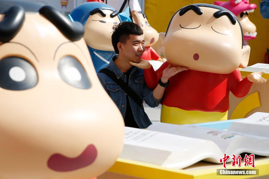 4月22日，游客與蠟筆小新合影。“蠟筆小新25周年紀(jì)念特展”日前在北京開(kāi)展，吸引了不少市民游客。