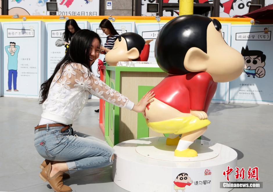 4月22日，游客與蠟筆小新合影?！跋灩P小新25周年紀(jì)念特展”日前在北京開(kāi)展，吸引了不少市民游客。