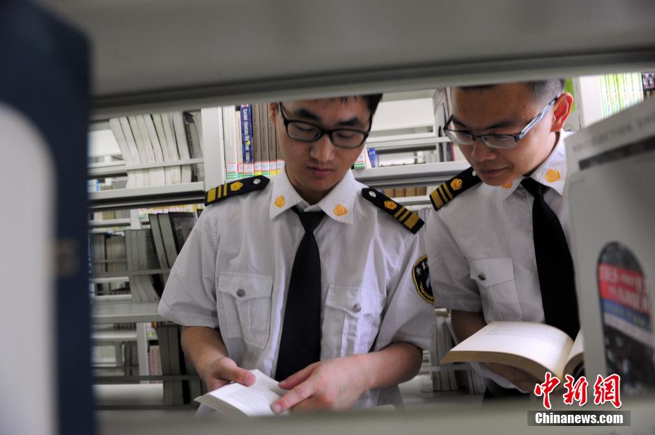 5月8日，武漢輕工大學(xué)圖書館保安吳濤與江力在圖書館交流學(xué)習(xí)。