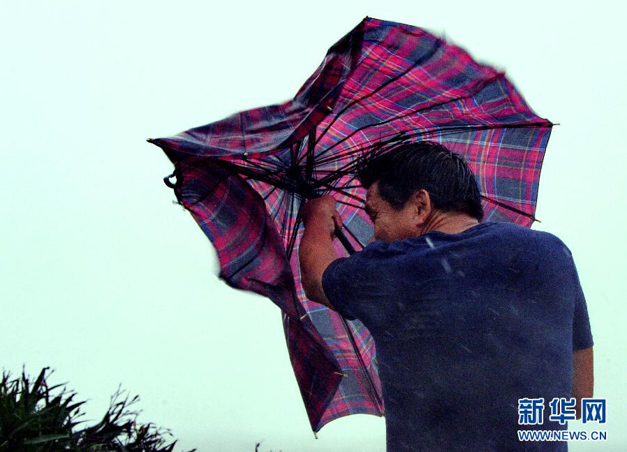 8月8日，福建省石獅市漁民在風雨中前行。