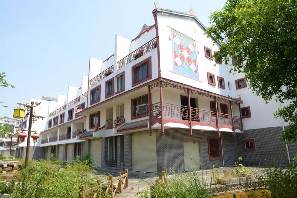 2016年7月26日，村民在廣西來賓市忻城縣隆達(dá)山水福城荒廢別墅間放牛。