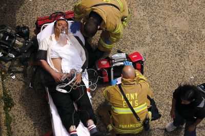 2日，救援人員在美國(guó)紐約地鐵事故車輛內(nèi)緊急疏散一名受傷乘客。圖/CFP