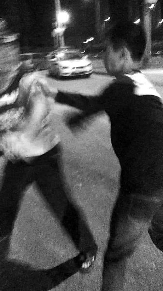 一名男子扯著民警的反光背心一路追打。