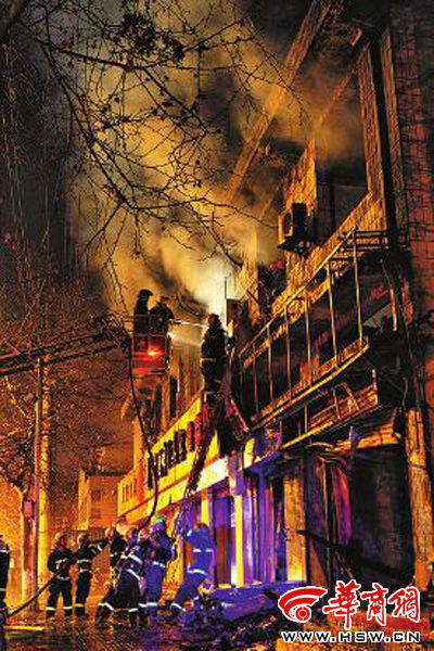 昨日22時10分，西安市豐慶路南小巷南口，消防官兵架梯子登上二樓施救 本組圖片由本報記者 閆文青 攝