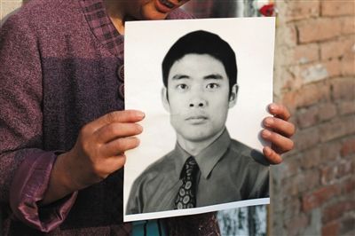 5月19日，朝陽(yáng)北路，母親捧著張東文的遺像。新京報(bào)記者 侯少卿 攝