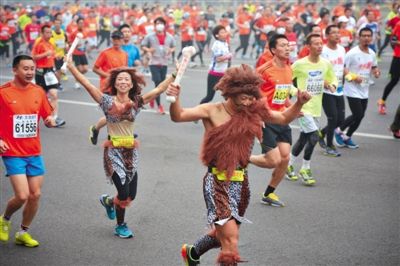 “原始人”打扮的參賽者向觀眾揮手。