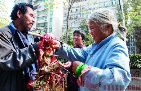 一個(gè)過路市民在挑選高廣林做的香包。
