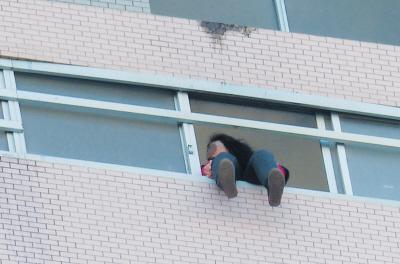 28樓的窗臺上坐著一名女子，其兩條腿耷拉在室外，不停地擺動。