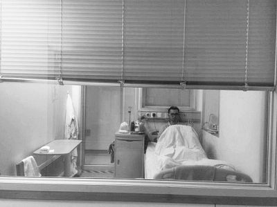 楊杰在醫(yī)院隔離病房中，沖記者揮了揮手。