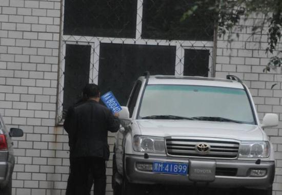 程父與程的“司機(jī)”在居住小區(qū)內(nèi)將黑AB0040車(chē)牌更換為黑M41899車(chē)牌，倆車(chē)牌號(hào)均為空號(hào)